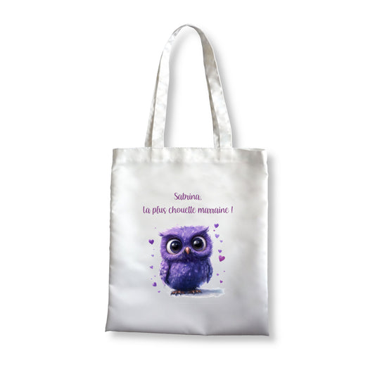 Totebag blanc avec un dessin d'une chouette violette avec de gros yeux et entourée de coeurs.
