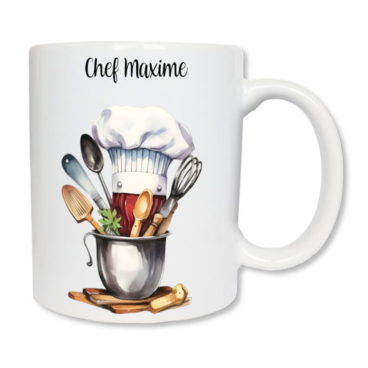 Mug personnalisé en céramique blanc  de 325 ml avec le dessin d'une toque de cuisine et des ustensiles, et personnalisé avec un prénom. Cadeau pour cuisinier /cuisinière.