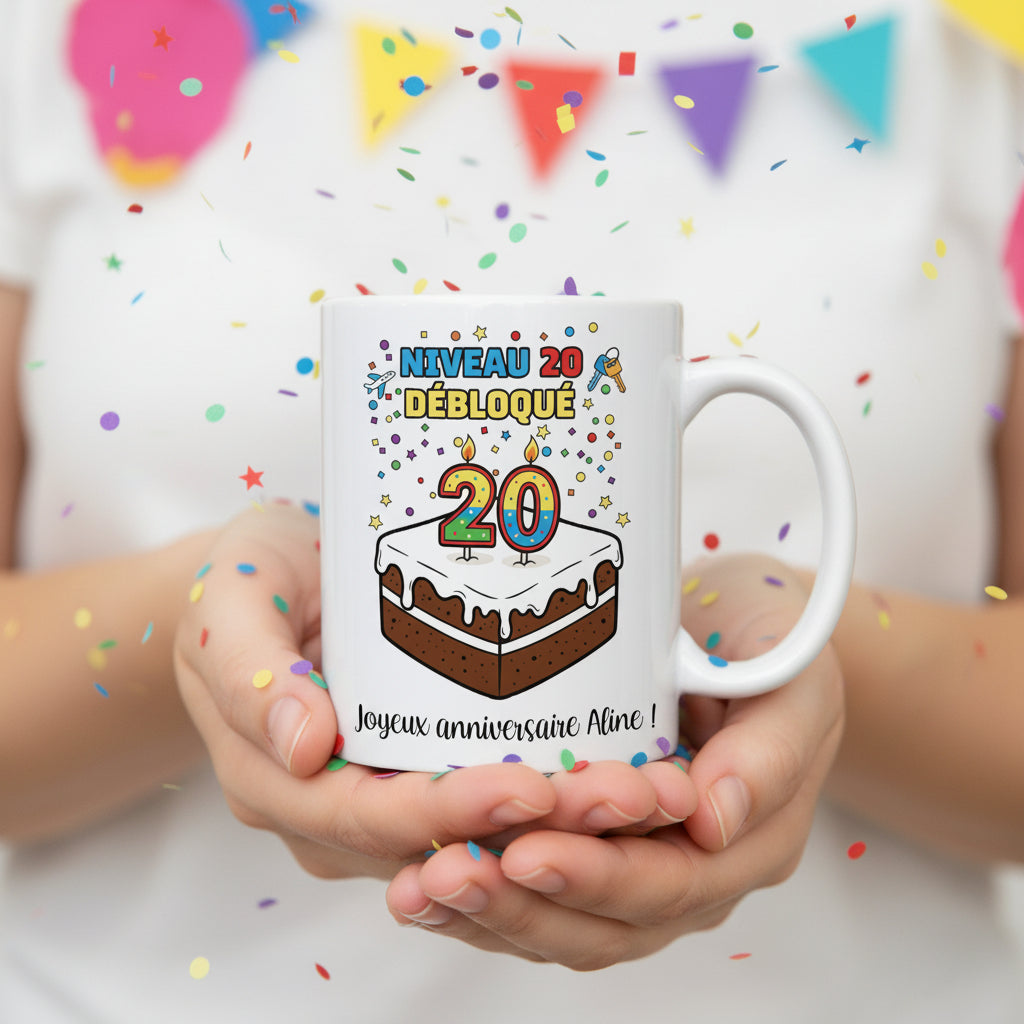 Mug personnalisé 20 ans tenu à deux mains avec confettis colorés, illustration gâteau et "Niveau 20 débloqué"

