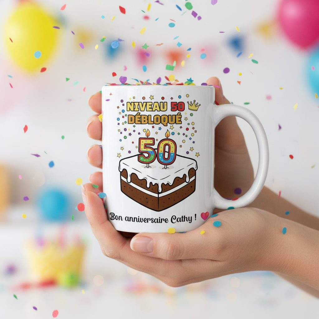 Mug personnalisé 50 ans tenu à deux mains avec ballons colorés et confettis, illustration gâteau et "Niveau 50 débloqué"
