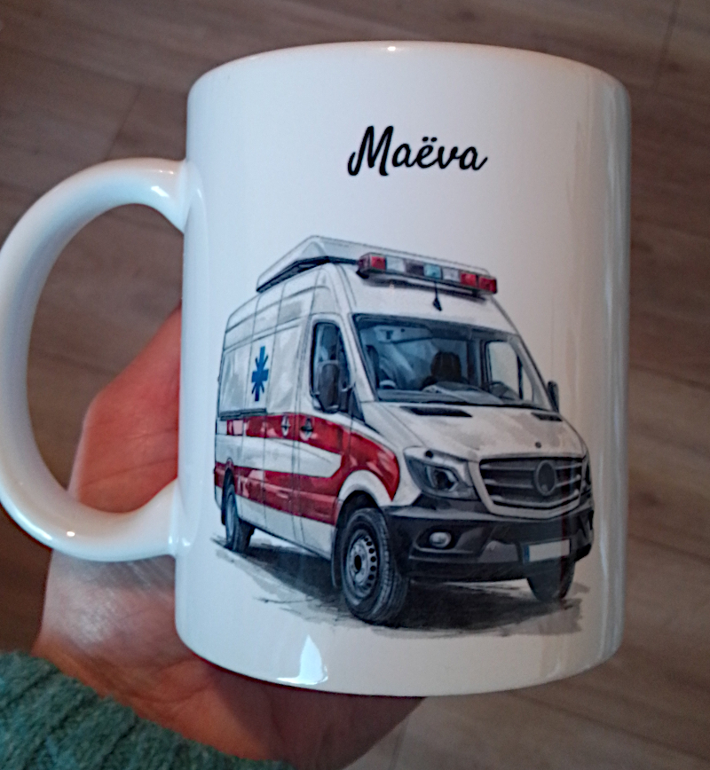 Mug blanc en céramique de 325ml avec un camion ambulance,  et personnalisé avec un prénom. Cadeau pour ambulancier / ambulancière.