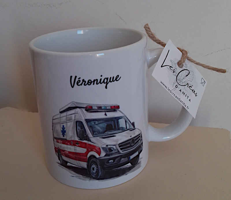 Mug blanc en céramique de 325ml avec un camion ambulance,  et personnalisé avec un prénom. Cadeau pour ambulancier / ambulancière.
