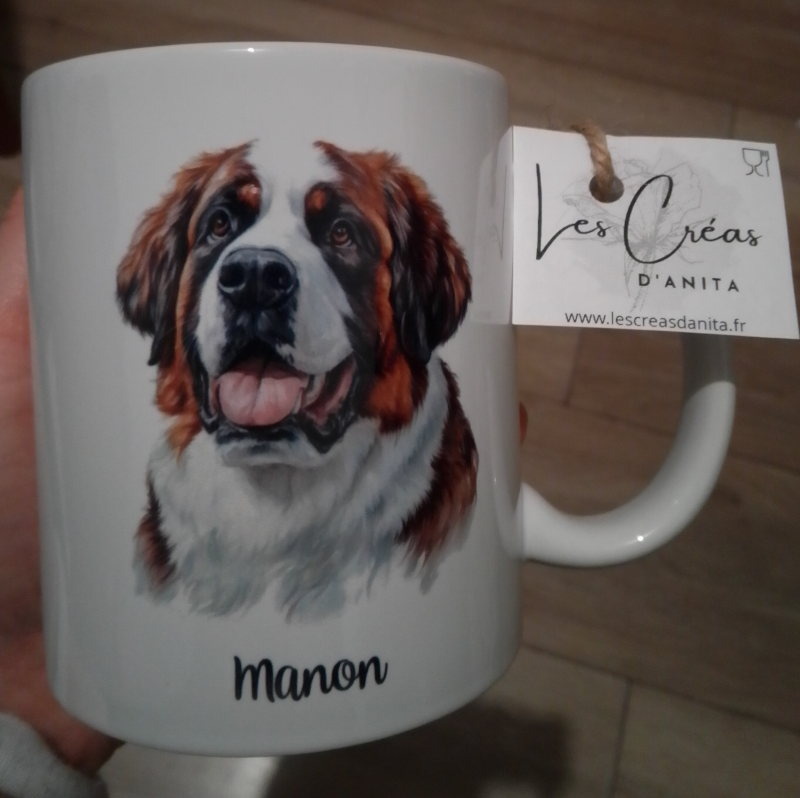 Mug blanc en céramique de 325 ml avec un dessin représentant la tête d'un chien Saint-bernard de face  et personnalisé avec un nom. Idée cadeau originale