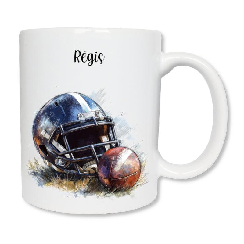 Mug blanc en céramique  de 325 ml avec le dessin d'un casque noir et d'un ballon de rugby posé  sur de l'herbe, et personnalisé avec un prénom - Idée cadeau entraîneur