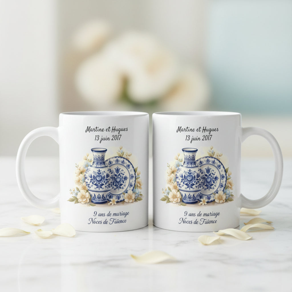 Duo de mugs personnalisés 9 ans de mariage Noces de Faïence, posés sur un marbre blanc avec pétales ivoires, illustration vase et assiette bleu de Delft
