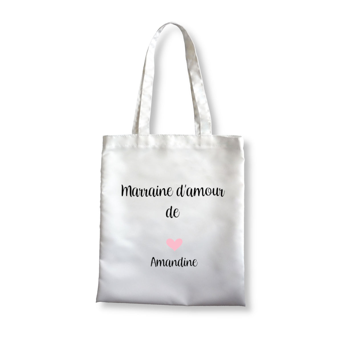 Tote bag personnalisé blanc en polyester avec message pour une marraine. En bas il y a un coeur avec le prénom de la filleule